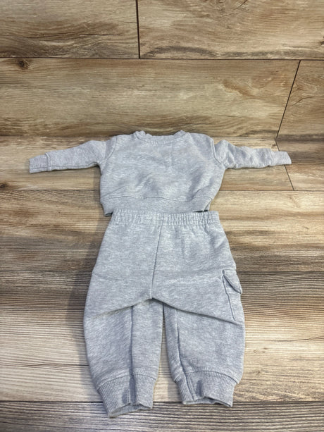 Grey 2-piece pullover sweatshirt and joggers set for babies on a wooden background.