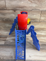 Angled top view of Hasbro Spidey playset showing red cockpit, blue web ramp and articulated legs on wood floor
