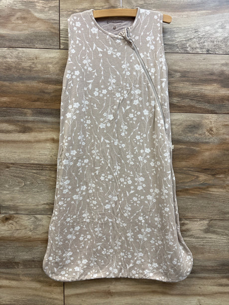 Front view of günamüna 0.5TOG sleeveless bamboo sleep sack in Magnolia Tan with white floral pattern and diagonal zipper on wood