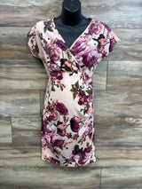 Front view of Pinkblush rose floral wrap maternity dress showing V-neck wrap and fitted belly on wood background