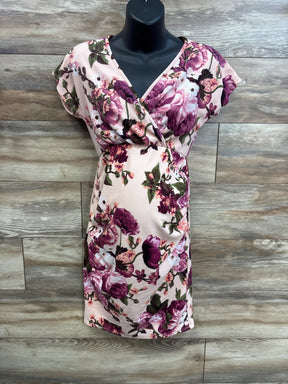 Front view of Pinkblush rose floral wrap maternity dress showing V-neck wrap and fitted belly on wood background
