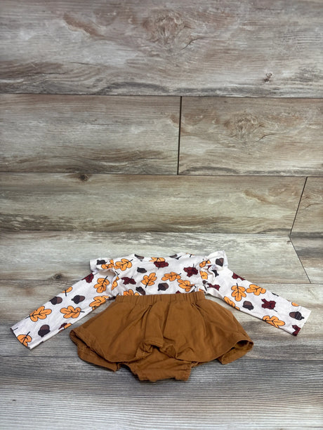 Front view of Thanksgiving long sleeve bodysuit dress with autumn leaf print and brown skirted bottom on wood-look floor