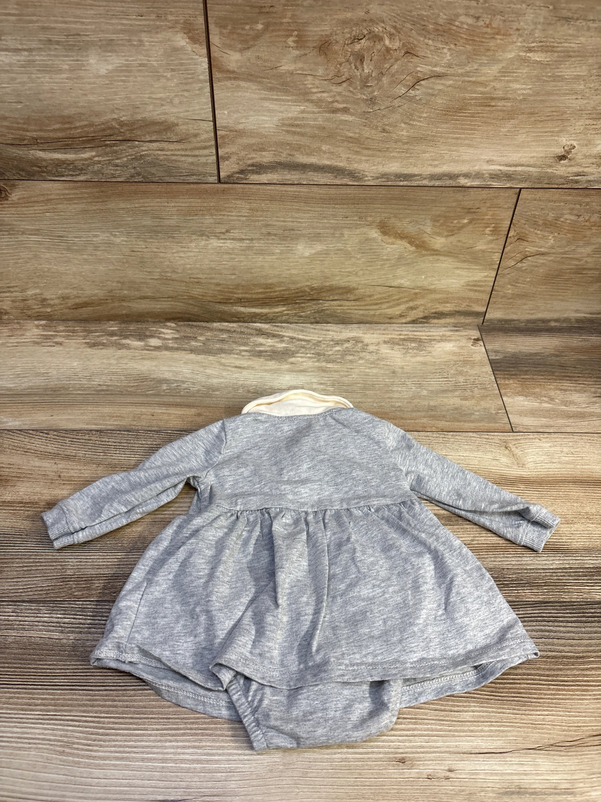 Front view of Carter’s grey polo bodysuit dress showcasing long sleeves, attached bloomers, and white collar on a wood-look floor