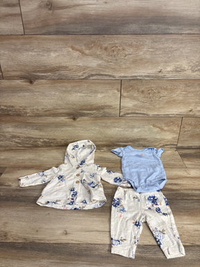 Floral baby girl outfit with hooded jacket, matching pants, and blue bodysuit on wood floor