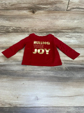 Flat lay front of red Cat and Jack long sleeve baby shirt showing gold BRING THE JOY print on wood floor background