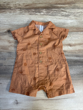 Rust-colored baby romper with sun pattern, short sleeves, and front buttons on wood background.