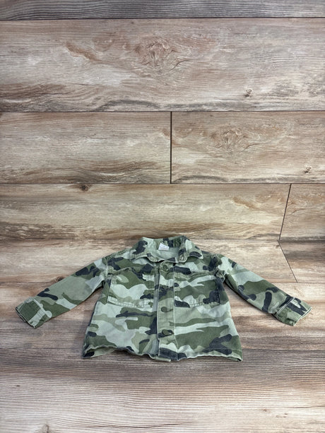 Front view of toddler camo denim jacket size 2T showcasing button-front closure and chest pockets with wood plank background