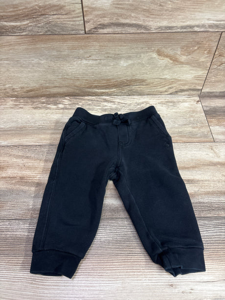 Front view of Ralph Lauren black ribbed joggers showcasing a drawstring waist, side pockets, and cuffs on a wood floor