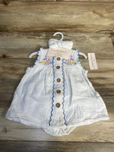 White infant romper with wooden buttons, floral embroidery, and coordinating headband on hanger