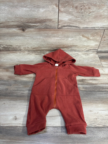 Rust-colored baby fleece hooded romper with front zipper and pockets on wood floor