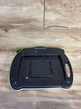 Rear of VTech Write & Learn Creative Center with battery compartment, handle, and green stylus cord on wood background