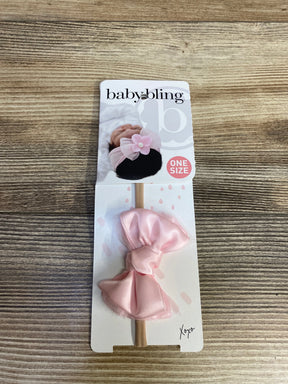 Baby Bling pink bow headband for infants on branded packaging, displayed on wood surface