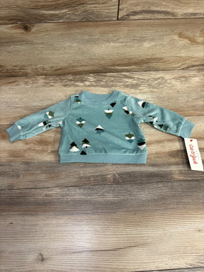 Light blue baby sweatshirt with geometric tree pattern on wooden background