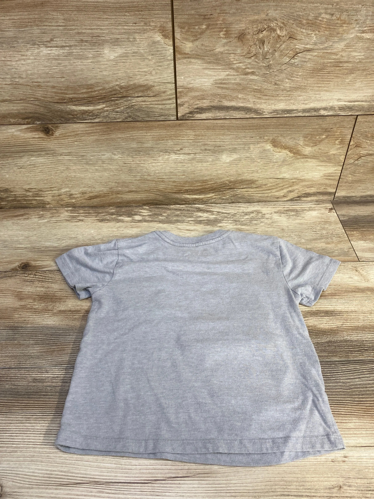Back view of Bluey pocket t-shirt in heather grey, size 4T showing short sleeves and straight hem on wood background