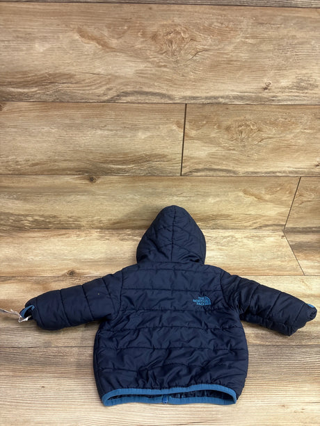 Back view of The North Face Reversible Perrito Hooded Jacket in navy, showcasing hood and quilted padding on wood flooring