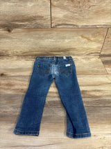 Back view of blue 7 For All Mankind jeans, size 24m, showing elastic waistband and embroidered back pockets on wood floor