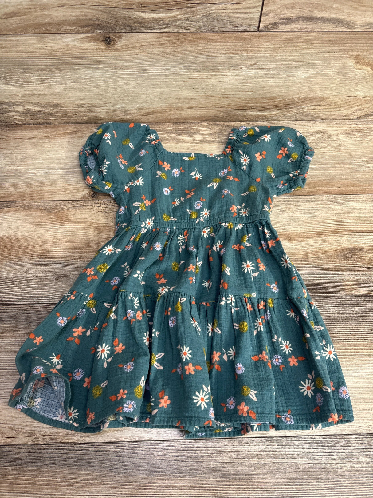 Green floral puff sleeve toddler dress on wooden floor, kids clothing resale item