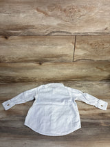 White long sleeve toddler shirt with button cuffs on wood background