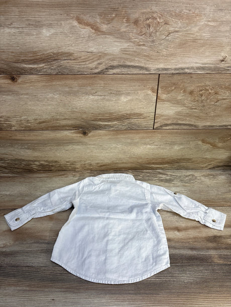 White long sleeve toddler shirt with button cuffs on wood background