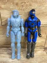 Front view of two 12-inch Halo Spartan figures: light-blue active camo and blue-gray Master Chief on wood background