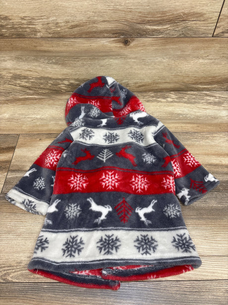 Front view of a plush hooded bath robe with red, navy, white snowflake and reindeer pattern on a wood floor