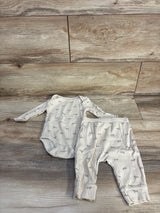 Flat lay of beige ribbed bodysuit and matching pants with ribbed texture and gray print on wood floor background