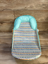 Top-down view of Summer Infant by Ingenuity Foldaway 2-Position Baby Bather showcasing turquoise padded headrest and wave-patterned mesh support with wood floor background
