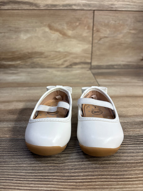 Front view of Wonder Nation girls' white bow ballet flats showing elastic strap and tan rubber sole on wood-grain background