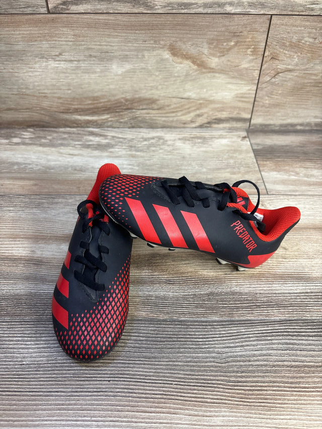 Top front view of Adidas Predator 20.4 youth soccer cleats, black with red stripes and textured forefoot, on wood-look floor