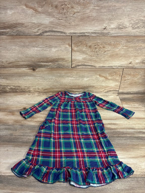 Plaid toddler dress with ruffled hem, festive red green blue pattern, long sleeves, laid on wood floor