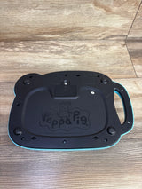 Bottom view of a Peppa Pig branded children's electronic device in black and teal on wooden floor