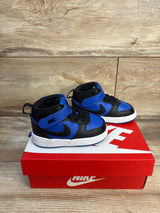 Angled view of Nike Court Borough Mid toddler sneakers in black and game royal showing Velcro strap on red Nike box