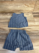 Flat lay of blue striped henley tank and matching elastic-waist shorts, size 6 months, on wood background