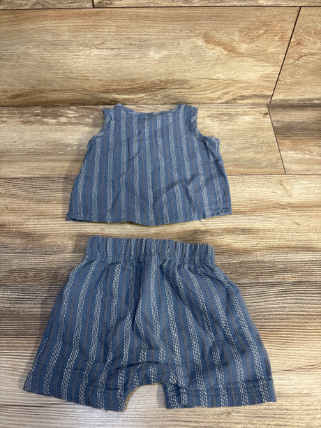 Flat lay of blue striped henley tank and matching elastic-waist shorts, size 6 months, on wood background