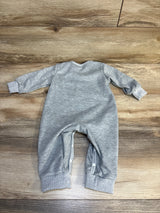 Gray long sleeve baby romper with snap buttons, displayed on wood floor