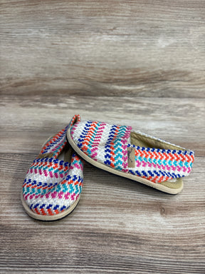 Colorful woven slip-on toddler shoes with multicolored stripes on wooden surface