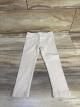 Flat lay of beige Carter's ribbed leggings, size 3T, showing rib texture and elastic waist on light wood floor