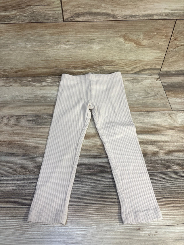 Flat lay of beige Carter's ribbed leggings, size 3T, showing rib texture and elastic waist on light wood floor