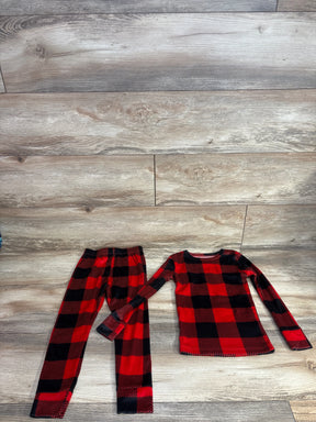 Red and black plaid kids pajama set with long sleeves and pants on wood floor