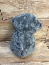 Gray plush teddy bear toy with soft fur on wooden background