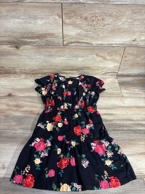 Girls black floral dress with colorful flower print, short sleeves, laid on wooden floor