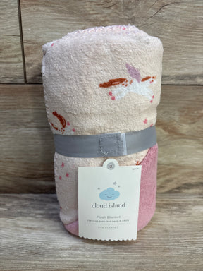 Front view of Cloud Island plush baby blanket showcasing unicorn print and pink plush backing with hang tag on wood background