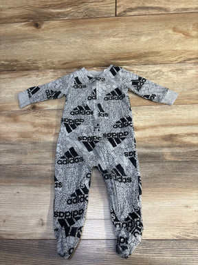 Gray Adidas baby onesie with black logo print laid flat on wooden floor, children's clothing