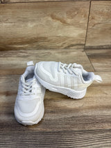 Angled view of Adidas Multix toddler sneakers size 4C showing white mesh upper, three stripes, and cushioned white sole on a wooden floor