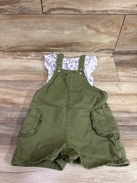 Front view of Obaibi floral shirt and olive green shortalls set showcasing buttoned straps and side pockets on a wood floor