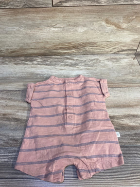 Flat lay of newborn Little Planet Organic shortie romper in muted orange with navy horizontal stripes and front snap placket on wood background