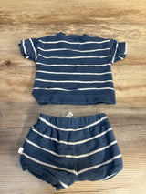 Navy blue baby outfit with white stripes, short sleeve top and matching shorts on wood background