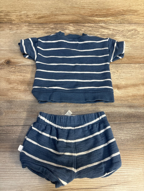 Navy blue baby outfit with white stripes, short sleeve top and matching shorts on wood background