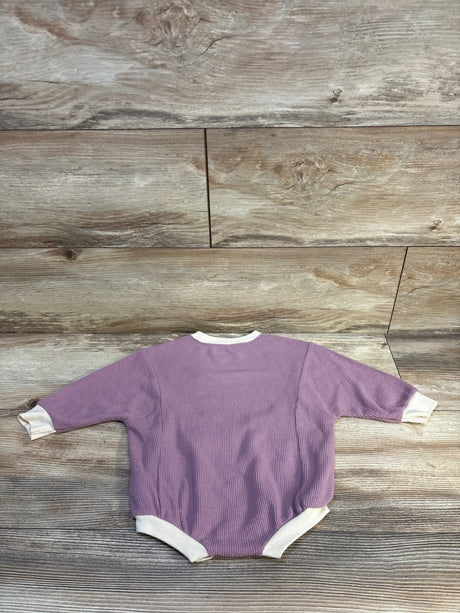 Back view of Cat and Jack lilac waffle-knit bubble romper 12m showing ribbed texture and white trim on wood plank floor