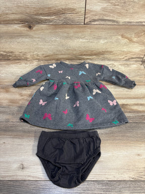 Gray butterfly print baby dress with black bloomers on wood floor